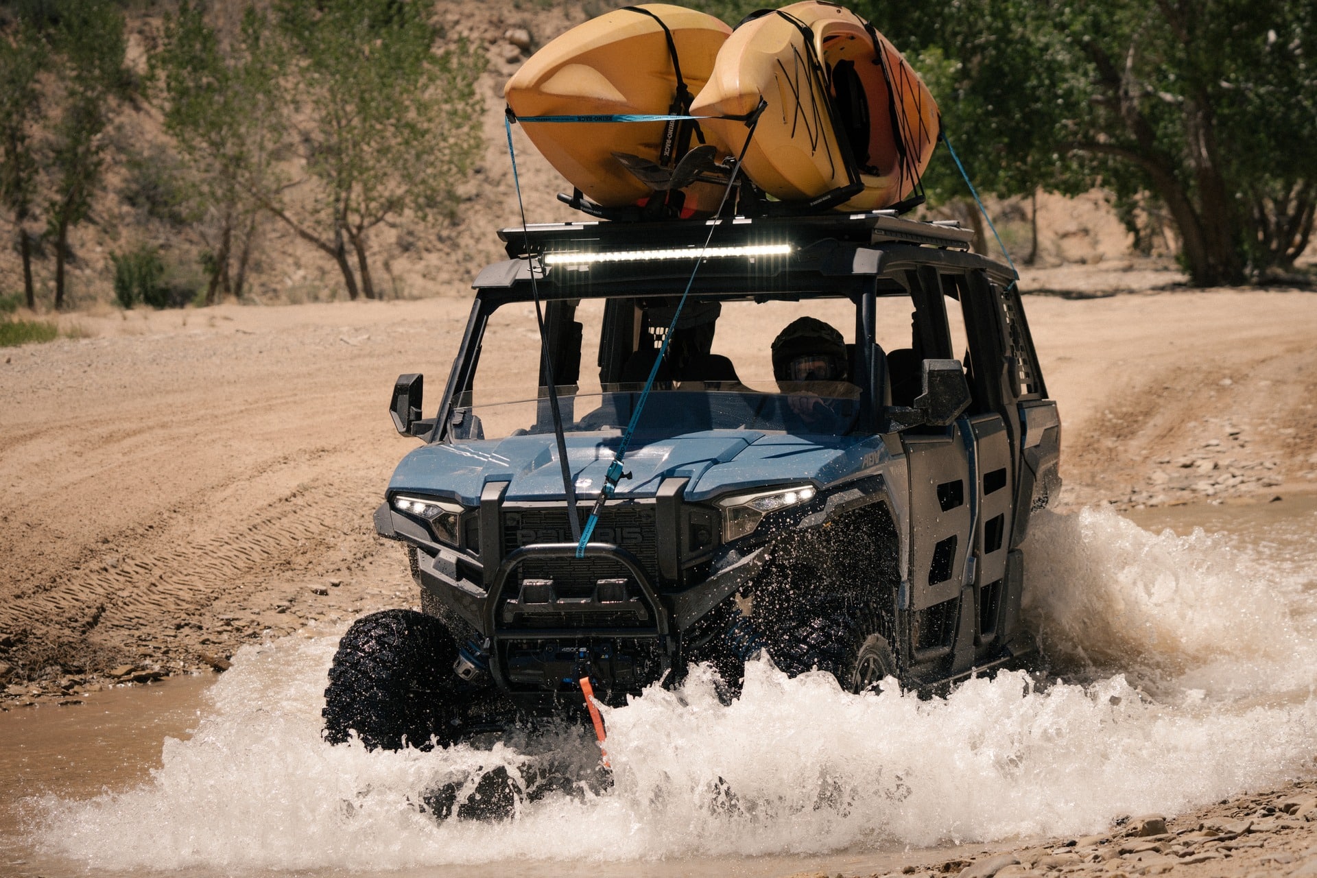 A Polaris Xpedition driving through the water.